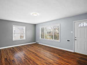 Foyer entrance with dark wood-type flooring and healthy amount of natural light