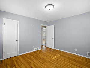 Unfurnished room with wood finished floors and baseboards