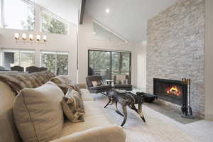 Living room with high vaulted ceiling and a stone fireplace