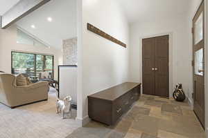 Foyer with high vaulted ceiling, stone tile floors, beam ceiling, and recessed lighting
