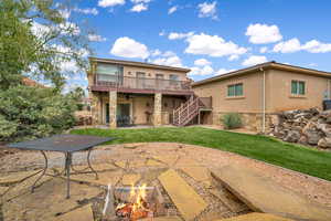 Back of house featuring a patio, stairs, a wooden deck, and stucco siding