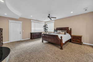 Bedroom featuring light carpet, ceiling fan, and recessed lighting
