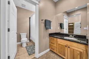 Full bathroom featuring a shower with curtain, vanity, light tile patterned flooring, and a walk in closet