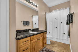 Bathroom featuring vanity, shower / tub combo with curtain, and light tile patterned floors