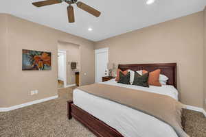 Bedroom with light carpet, recessed lighting, and a ceiling fan