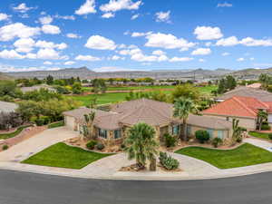 View of front of home with a mountain view, concrete driveway, a garage, and a front lawn