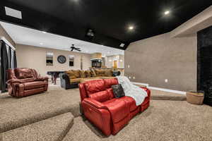 Carpeted cinema room with recessed lighting, ceiling fan, and lofted ceiling