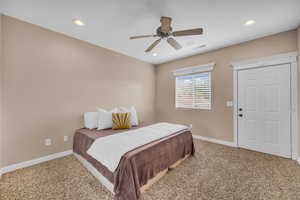 Carpeted bedroom featuring a ceiling fan and recessed lighting