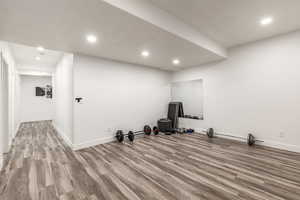 Exercise area with wood finished floors and recessed lighting