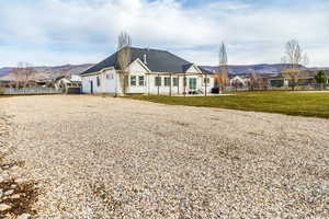 Single story home with gravel driveway, a mountain view, a patio area, and roof with shingles