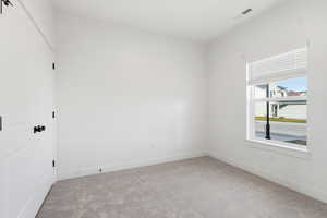 Spare room featuring light colored carpet and baseboards