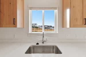 Kitchen view of light brown cabinets and light stone countertops