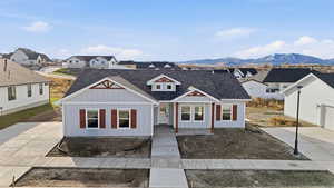 View of front of home featuring board and batten siding, covered porch, a residential view, and a shingled roof
