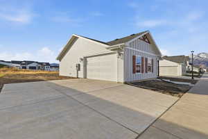 View of side of home with board and batten siding and driveway