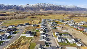 Aerial view of property and surrounding area featuring nearby suburban area and mountains