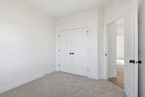 Unfurnished bedroom with carpet and a closet