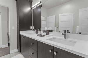 Full bath featuring double vanity and baseboards