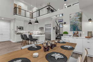 Dining room featuring stairway, a towering ceiling, and light wood finished floors