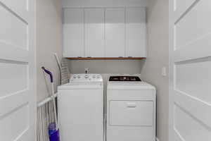 Washroom featuring cabinet space and washing machine and clothes dryer