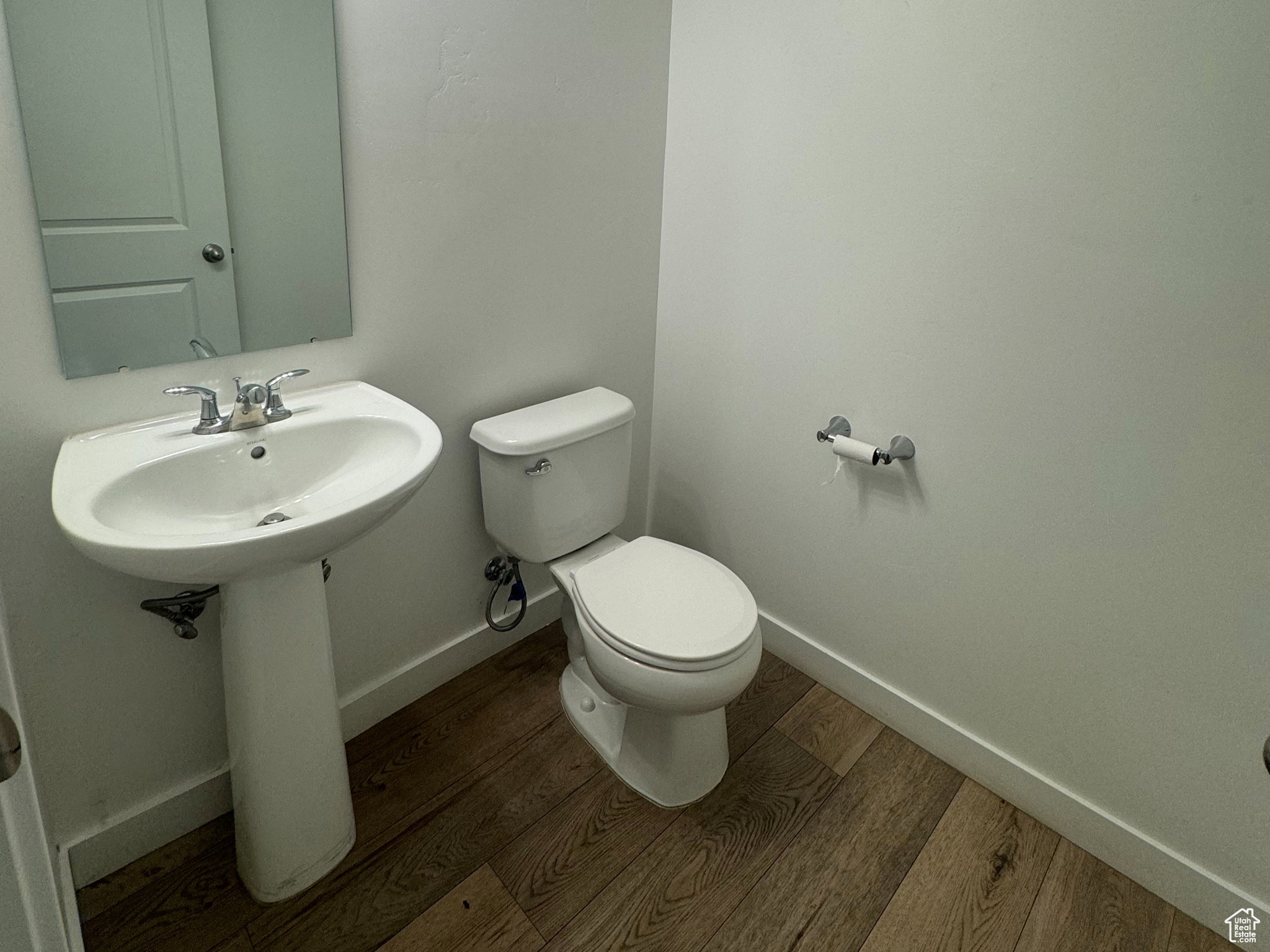 Bathroom featuring baseboards and dark wood-type flooring