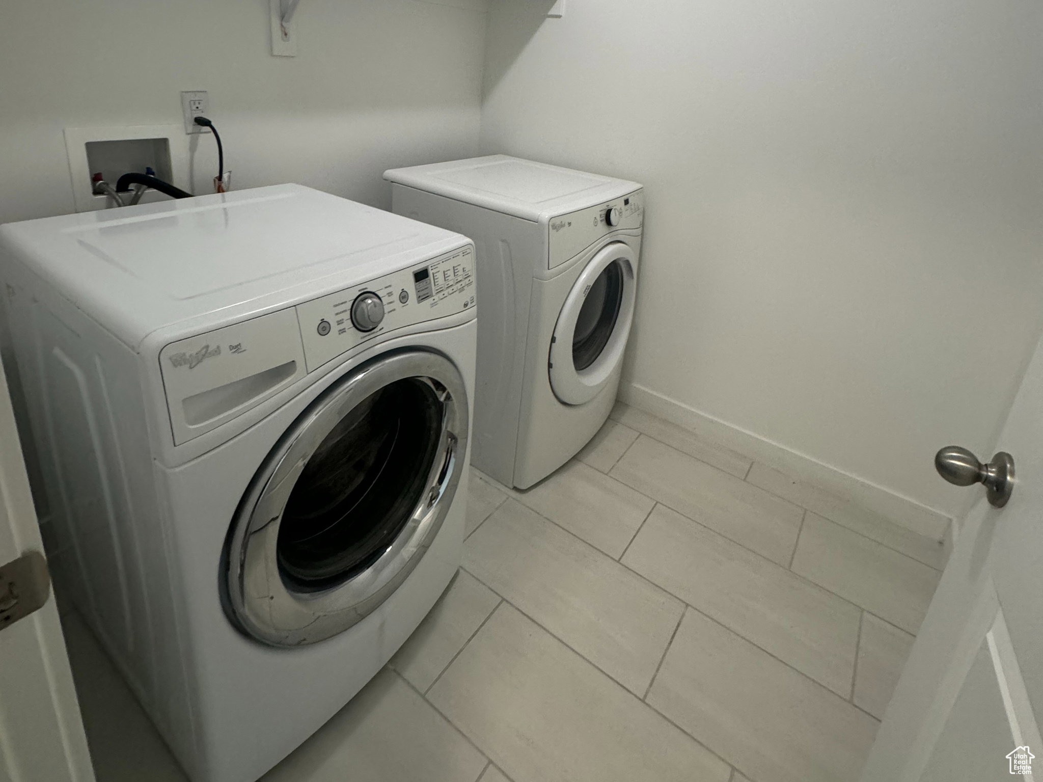 Washroom featuring washer and dryer and tile patterned flooring