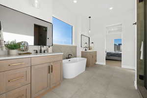 Ensuite bathroom with a soaking tub, two vanities, a stall shower, and recessed lighting