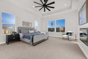 Bedroom featuring a tray ceiling, light colored carpet, a ceiling fan, and recessed lighting