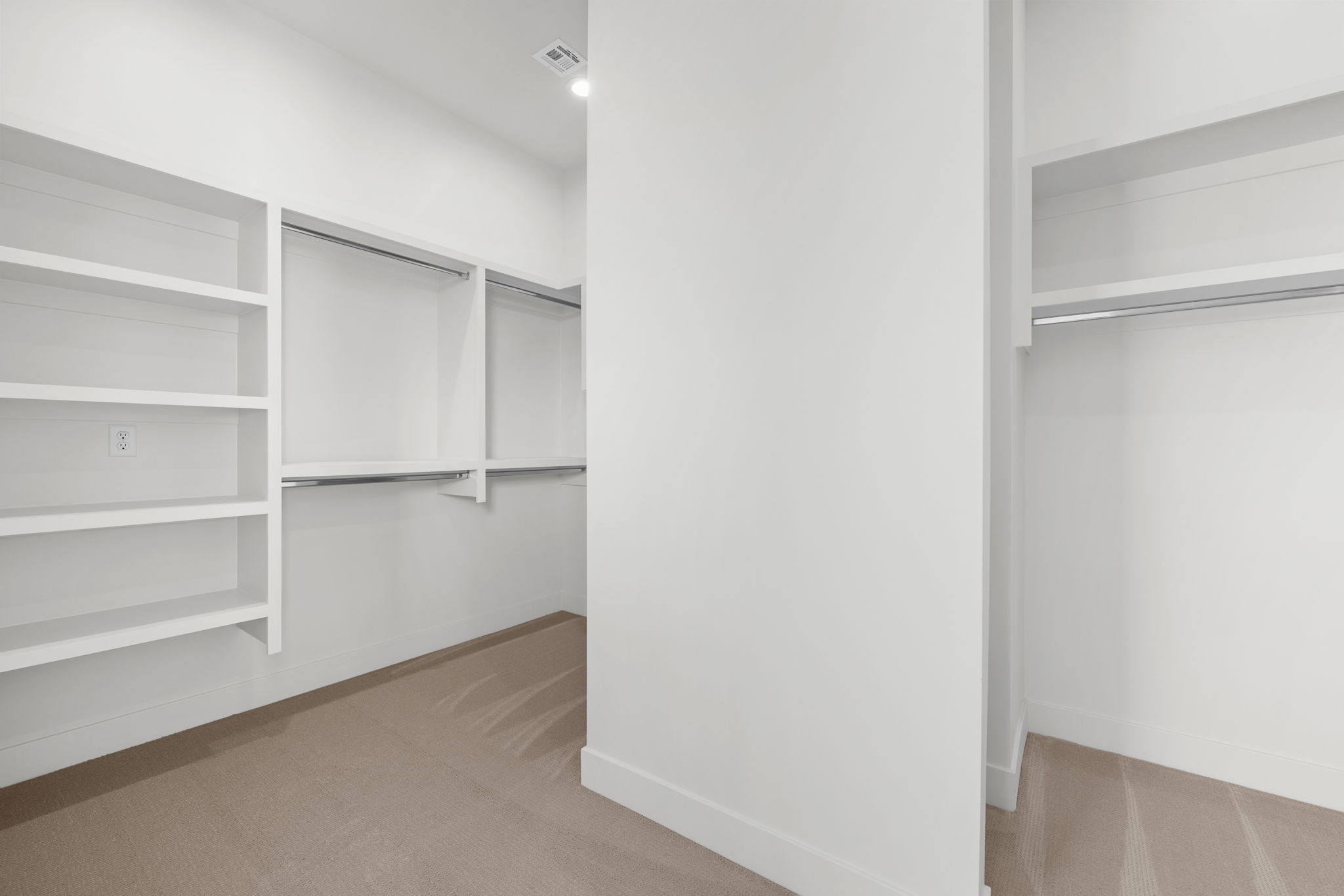 Walk in closet with light colored carpet