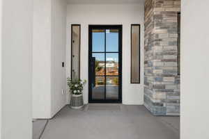 View of exterior entry featuring stucco siding and stone siding