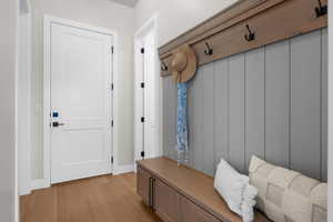 Mudroom featuring light wood-style flooring and baseboards