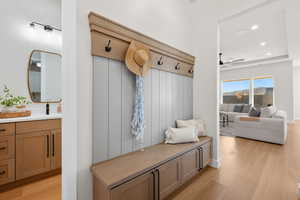 Mudroom with light wood-style floors, recessed lighting, a ceiling fan, and a tray ceiling