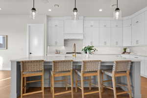 Kitchen featuring decorative light fixtures, a spacious island, a kitchen breakfast bar, decorative backsplash, and recessed lighting