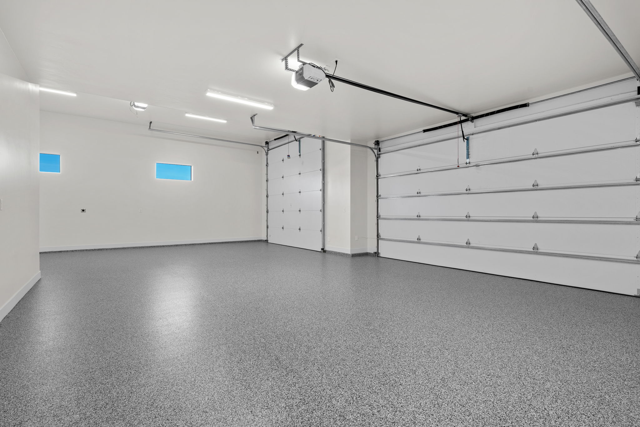 Garage featuring baseboards and a garage door opener