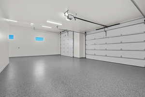 Garage featuring baseboards and a garage door opener