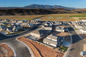 Aerial view of property and surrounding area featuring nearby suburban area and mountains