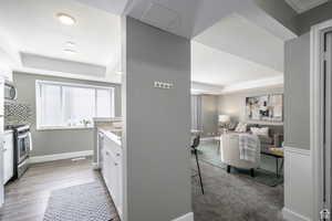 Kitchen featuring white cabinets, stainless steel appliances, a tray ceiling, and tasteful backsplash