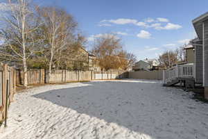 Snowy yard with a fenced backyard and a residential view