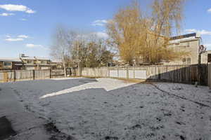 Snowy yard featuring a fenced backyard and a residential view