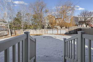 Fenced backyard featuring a wooden deck and a residential view