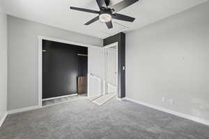 Unfurnished bedroom featuring light colored carpet, a closet, and a ceiling fan