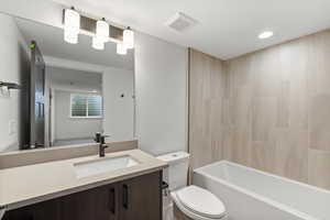 Full bath featuring vanity, shower / bath combination, and recessed lighting