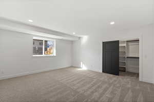 Unfurnished bedroom with light colored carpet and recessed lighting