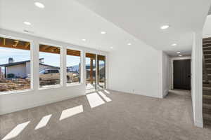 Empty room with stairs, light colored carpet, recessed lighting, and a sunroom