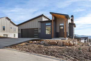 View of front facade featuring driveway, an attached garage, and a chimney