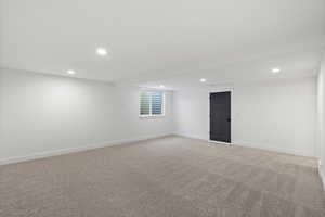 Basement with recessed lighting and light colored carpet