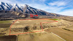 Aerial view of property and surrounding area with a mountainous background and property parcel outlined