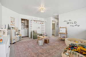 Recreation room with washer and dryer and light colored carpet