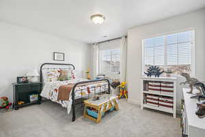 Bedroom featuring light carpet and baseboards