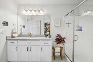 Bathroom with vanity, a shower stall, light marble finish flooring, and a spacious closet