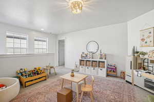 Living room featuring light colored carpet and a textured ceiling